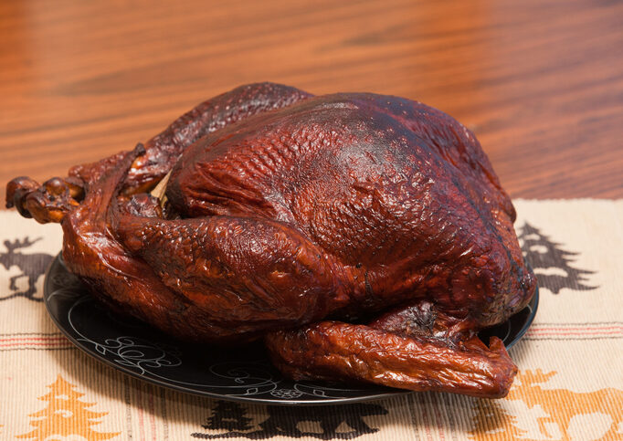 A turkey is sitting on the table ready to be cooked.