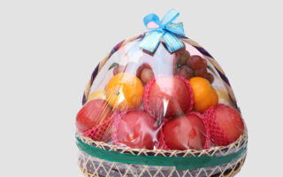 A basket of fruit is wrapped in plastic.