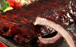 A close up of a plate with ribs and coleslaw