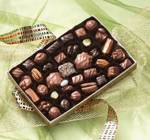 A box of chocolates on top of green cloth.