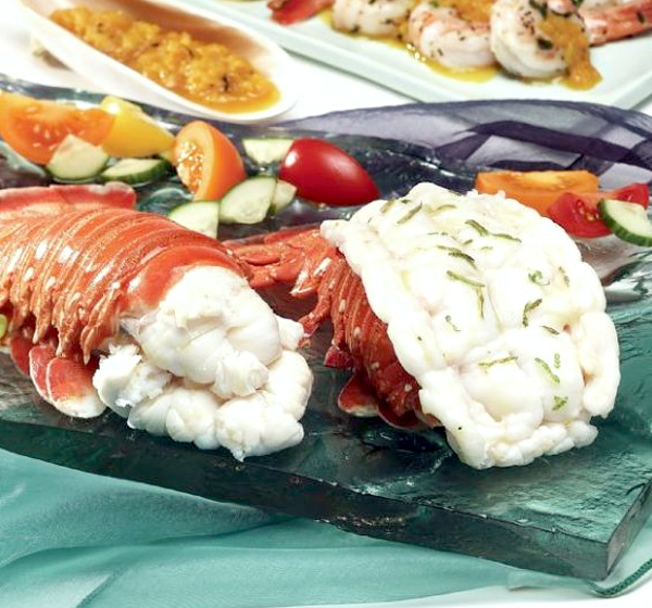 A lobster is on the plate with other food.