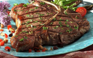 A large steak on top of a blue plate.